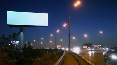 stock-footage-cars-rid-by-highway-with-empty-advertising-billboard-on-sidelines-at-night